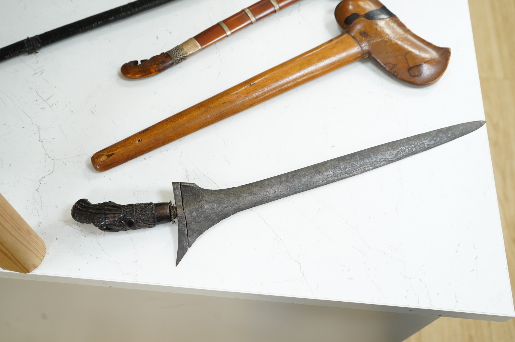 A Javanese dagger kris with straight pamor blade, wooden hilt carved as raksha, in its wooden sheath, together with a decorative dagger bade-bade, with etched blade